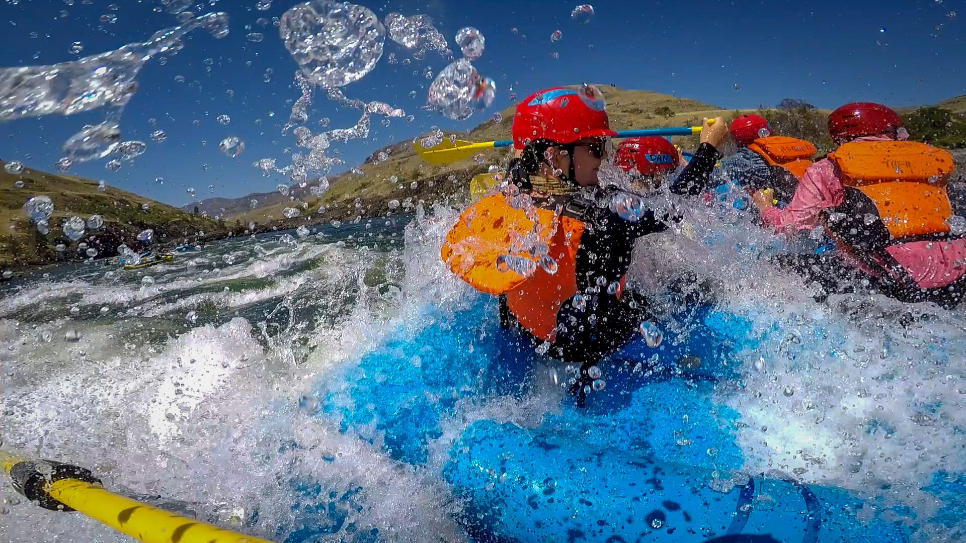 Photo of a student in a raft going through some rapids.